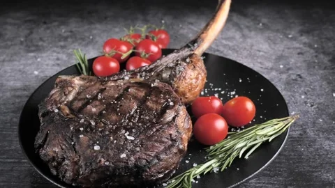 Ribeye Tomahawk Steak, Irish Beef, grilled, sprinkled with salt Stock Footage 194485180