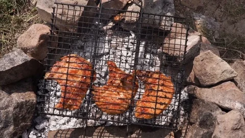Ribs on the grid roast on the coals, the cook flips the ribs on the coals Stock Footage 114630992