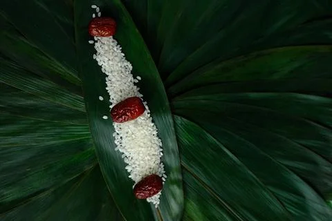 Rice and red dates on green leaf background Stock Photos