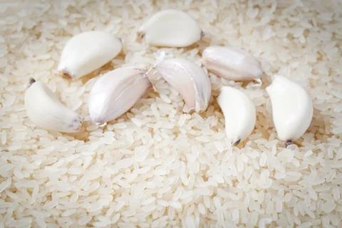 Rice background with garlic cloves Stock Photos