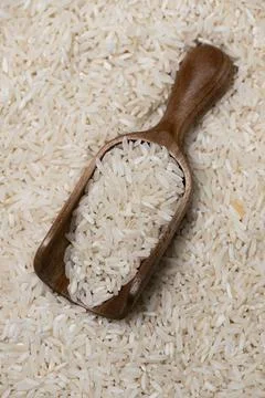 Rice background with texture. Rice in rustic scoop. Rice closeup for cooking. Stock Photos