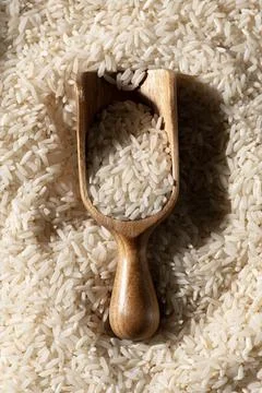 Rice background with texture. Rice in spoon for cereal. Rice close up. Stock Photos