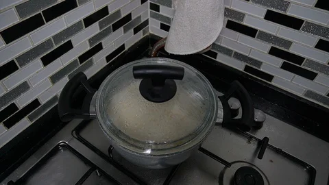 Rice is being cooked and the steam is getting off the pot - slow motion 2 times Stock Footage 129409511