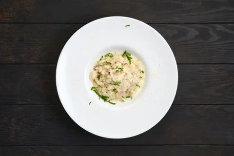 Rice with chicken pieces and grated cheese on dark wooden table Foto stock