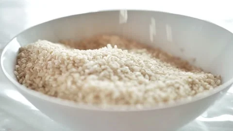 Rice close-up slowly falling into a white plate.Slow motion. Stock Footage 238722426