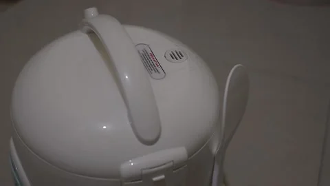 Rice cooker emitting steam while cooking rice Stock Footage 204852029