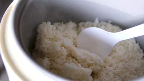 Rice cooker spoon spoon stir cooked white Thai jasmine rice in a rice cooker Stock Footage 306127846