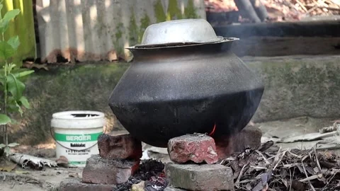 Rice cooking in a pot on a leaf-fueled, outdoor brick stove in rural Bangladesh. Stock Footage 320588078