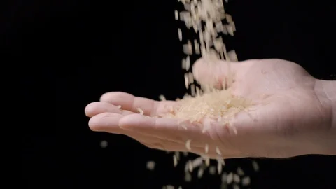 Rice falling in hand slow motion Stock Footage 99092609