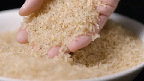 Rice falling in hand slow motion Stock Footage 99092684