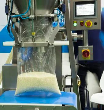 Rice fill into plastic by packing machine Stock Photos