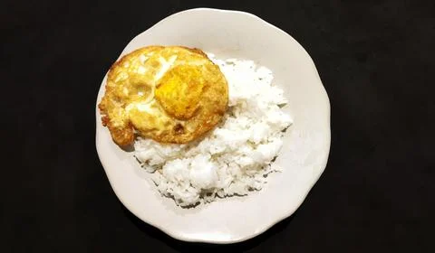 Rice with fried egg on black table Stock Photos