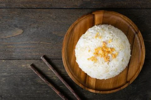 Rice with fried garlic in wooden dish on wooden table. Stock Photos