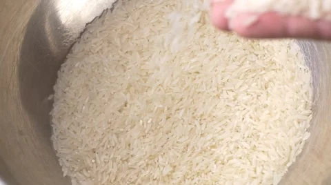 Rice grain falling through fingers falling slow-motion Stock Footage 54030321