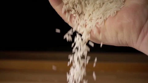 Rice grains falling from man's hand in slow motion Stock Footage 55235026