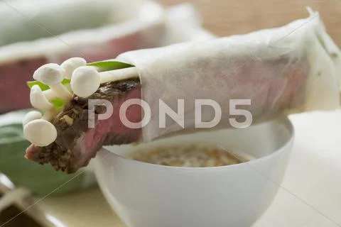 Rice paper rolls filled with beef & mushrooms, sesame sauce Stock Photos