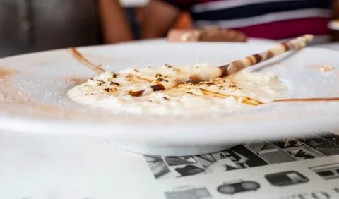 Rice pudding with chocolate chips and burnt sugar on white plate Stock Photos