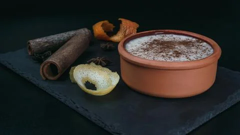 Rice pudding dessert served in an earthenware dish on a slate table accompani Stock Photos