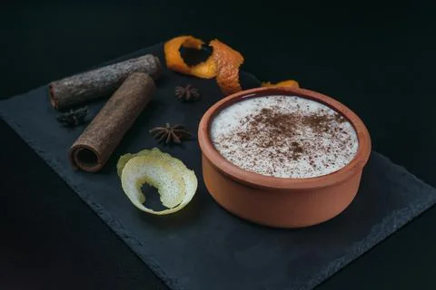 Rice pudding dessert served in an earthenware dish on a slate table accompani Stock Photos