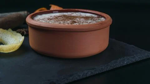Rice pudding dessert served in an earthenware dish on a slate table accompani Stock Photos
