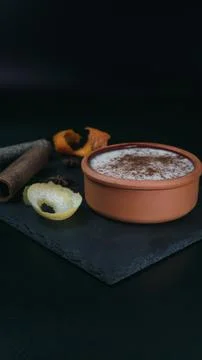 Rice pudding dessert served in an earthenware dish on a slate table accompani Stock Photos