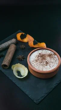 Rice pudding dessert served in an earthenware dish on a slate table accompani Stock Photos
