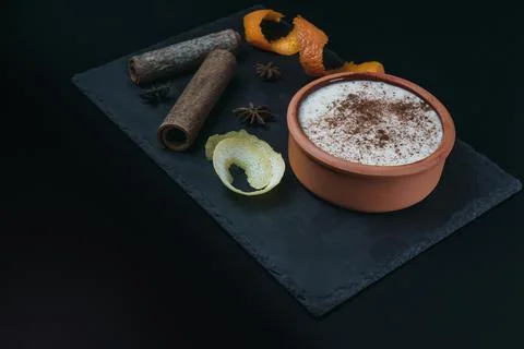 Rice pudding dessert served in an earthenware dish on a slate table accompani Stock Photos