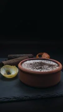 Rice pudding dessert served in an earthenware dish on a slate table accompani Stock Photos