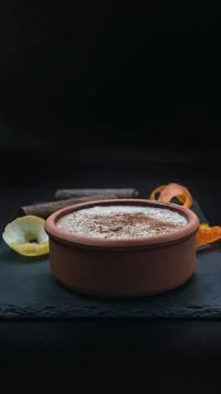 Rice pudding dessert served in an earthenware dish on a slate table accompani Stock Photos