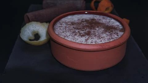 Rice pudding dessert served in an earthenware dish on a slate table accompani Stock Photos