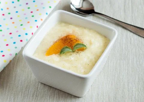 Rice pudding in a tall, square serving bowl. Dessert Stock Photos