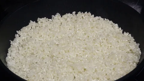 Rice for risotto poured wine slow mo Stock Footage 73106611