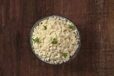Rice, shot from the top on a dark rustic wooden background, decorated with fresh 스톡 사진