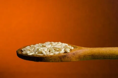 Rice in a spoon, close up, color background.. Stock Photos