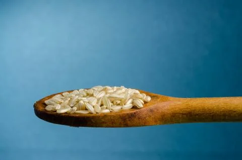 Rice in a spoon, close up, color background.. Stock Photos