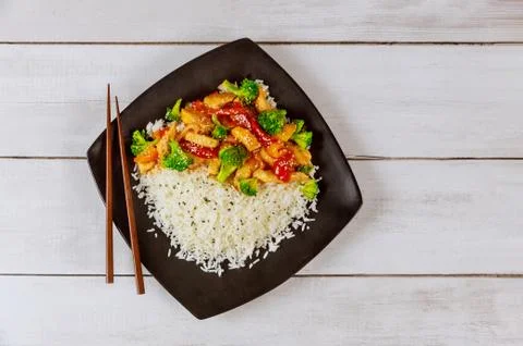 Rice with stir fry chicken and vegetable on black square plate. Chinese cuisi Stock Photos