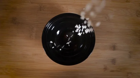 Rice on top rolls onto a black plate Stock Footage 124274941
