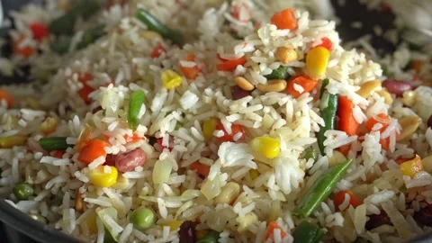 Rice with vegetables and nuts is mixed with a spatula. Cooking fried rice. Stock Footage 314893165