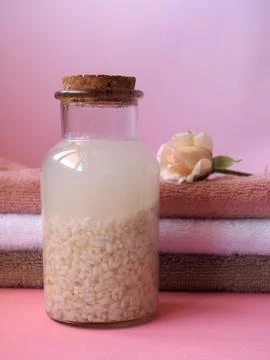 Rice water in a bottle. Against the background of terry towels Stock Photos