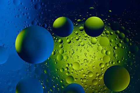 Rich background of round small drops of different sizes on blue green surface Stock Photos