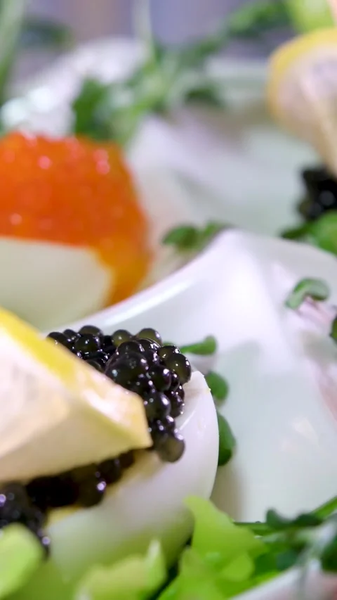 Rich live deviled eggs Luxury Hotel Red and black caviar on a plate spins on a 스톡 동영상 277043322