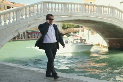 Rich man with cellphone smoking cigar in Venice Stock Footage