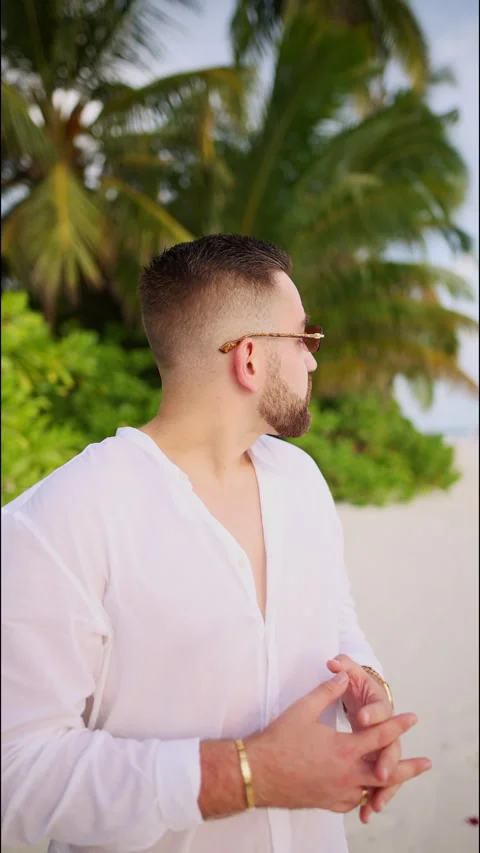 A rich man stands under the palm trees in the Maldives. vertical video Stock Footage 260221583