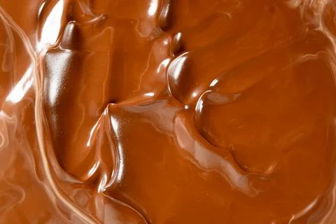 Rich melted chocolate flow background with glossy waves macro view Stock Photos