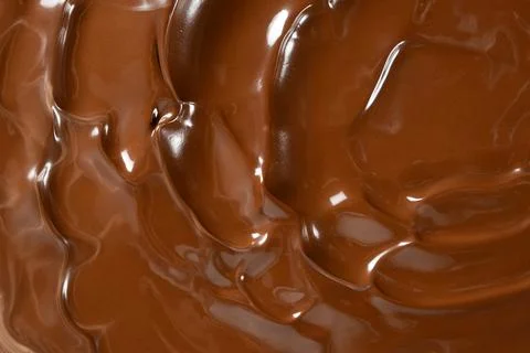 Rich melted chocolate flow background with glossy waves macro view Stock Photos