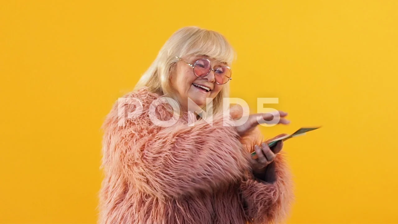 Rich old woman throwing around euro bills, celebrating lottery win, wealth