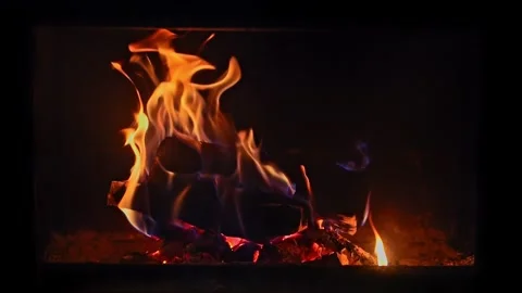 Rich orange flames dance in a fireplace, captured in slow motion, showcasin.. Video stock 264040436