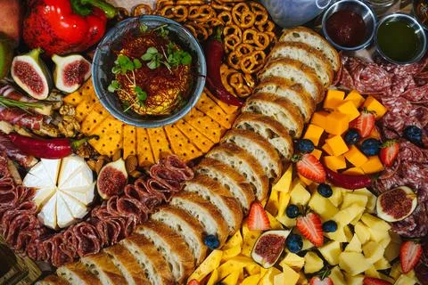 Rich table with different kind of snacks of cold meats bread cheese and fruits Stock Photos