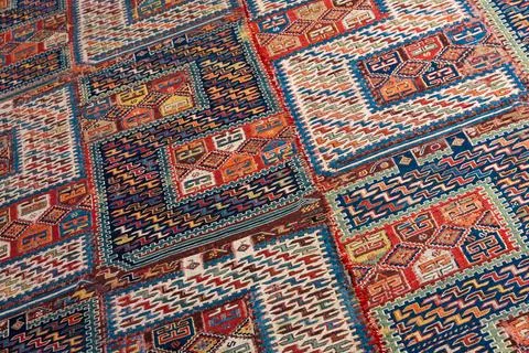 A richly patterned ancient handwoven rug featuring bold color blocks Stock Photos