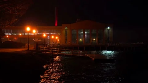 RICHMOND, CA - 2023 - A dockside warehouse at night with ocean waves. Stock Footage 264610308
